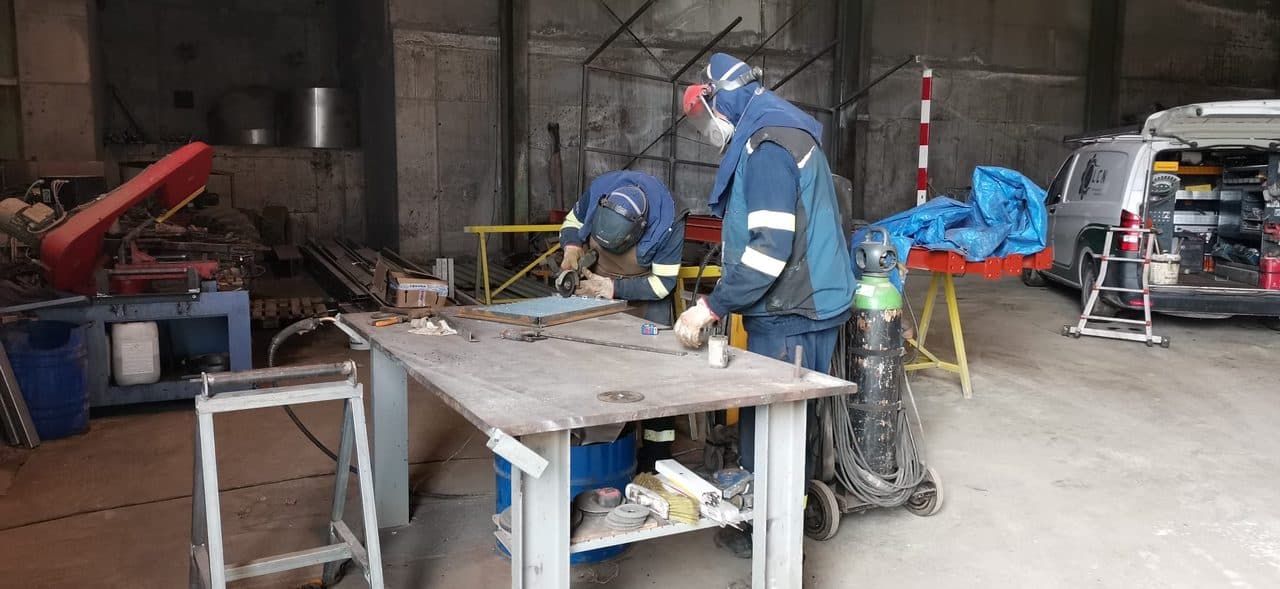Soldadores de Talleres Metálicos Luciano trabajando una pieza metálica a medida en el taller de Narón